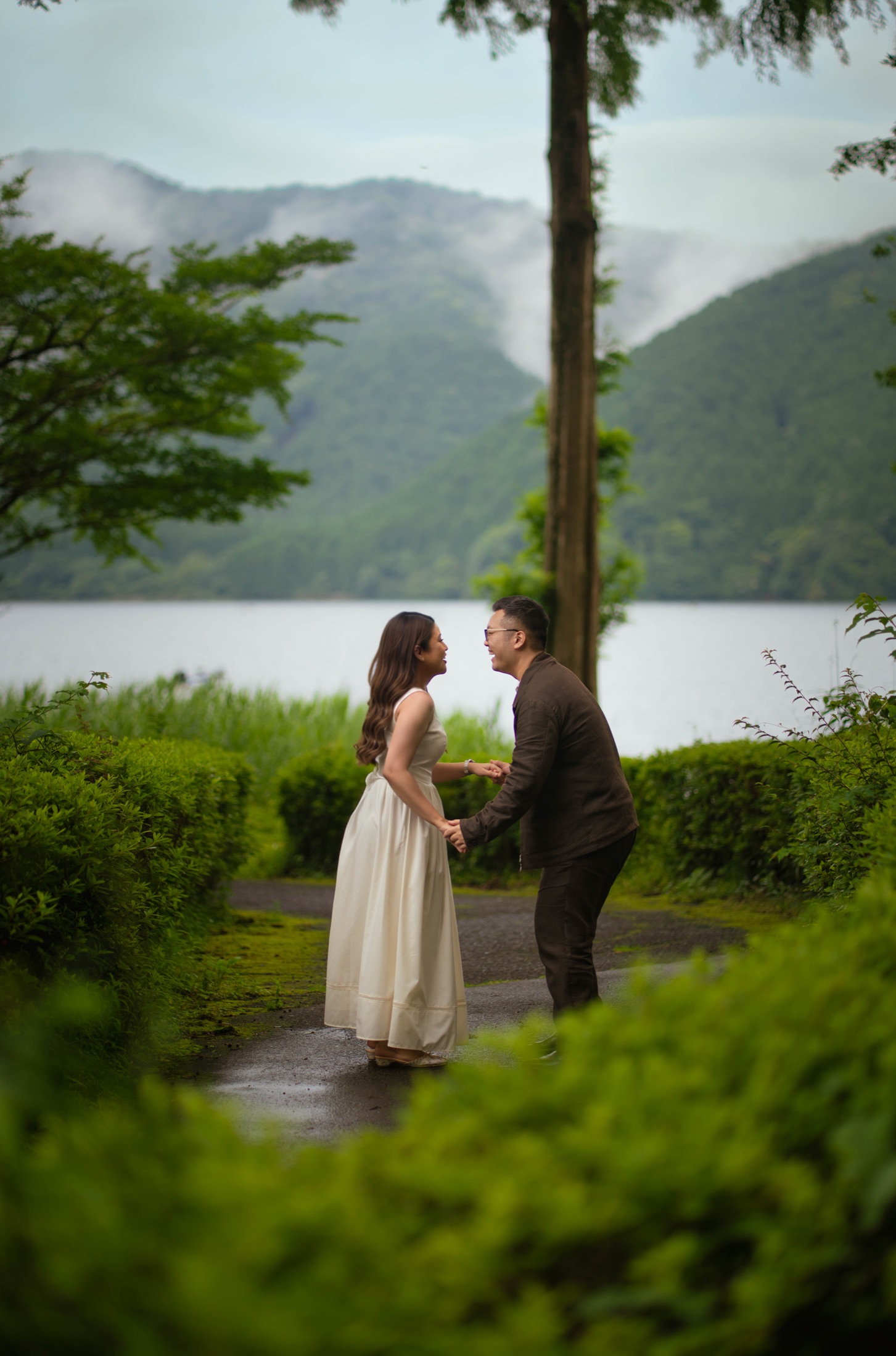 Declann and Afrina holding hands by a mountain lake