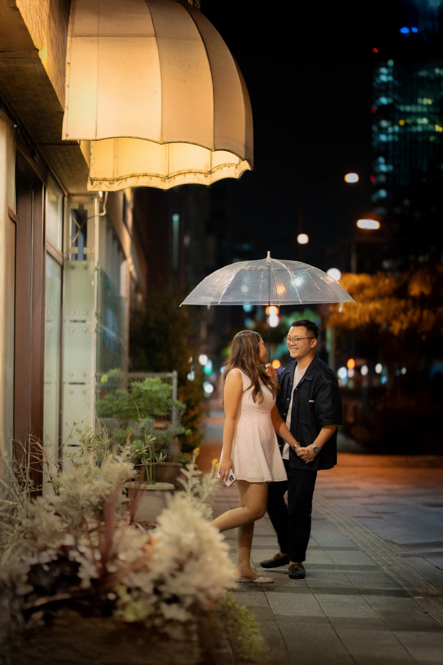 Declann and Afrina on a city street at night